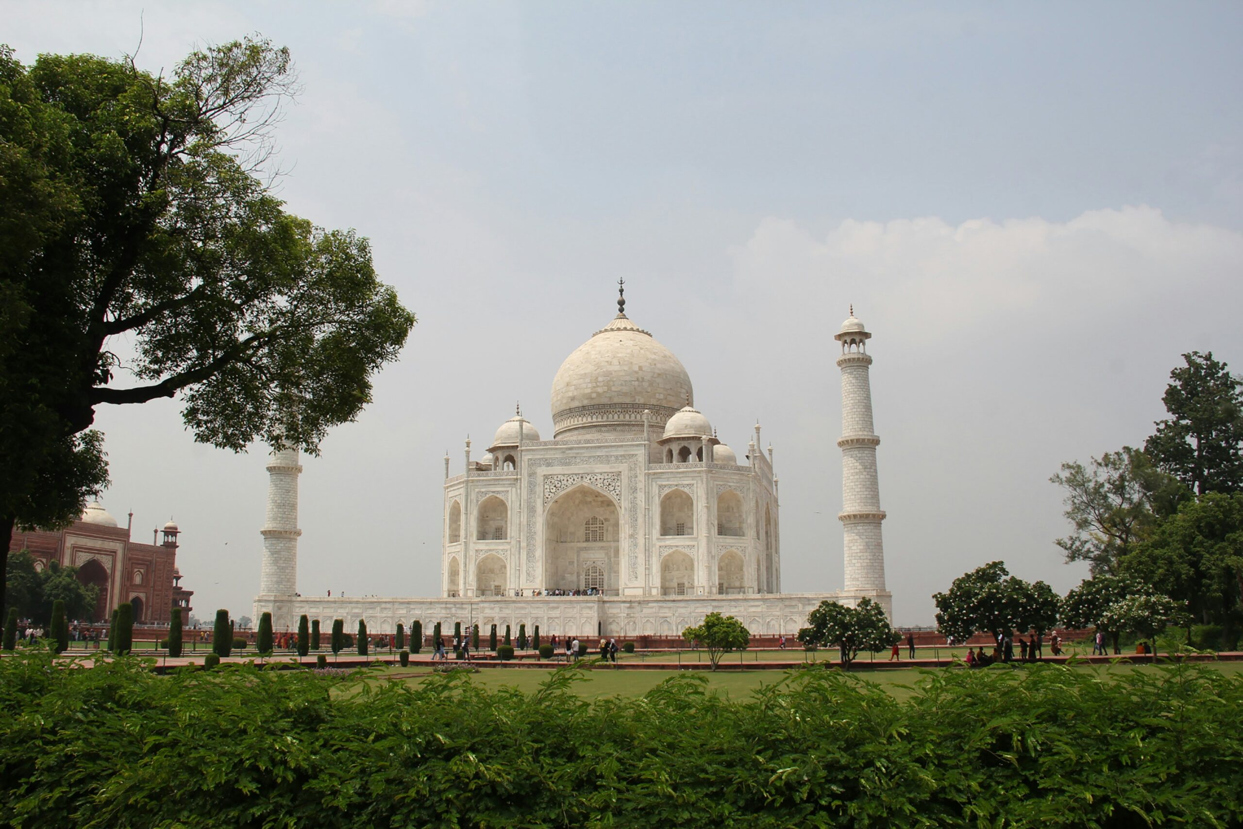 The Taj Mahal in Agra seen through the sandstone gateway arch at sunrise
