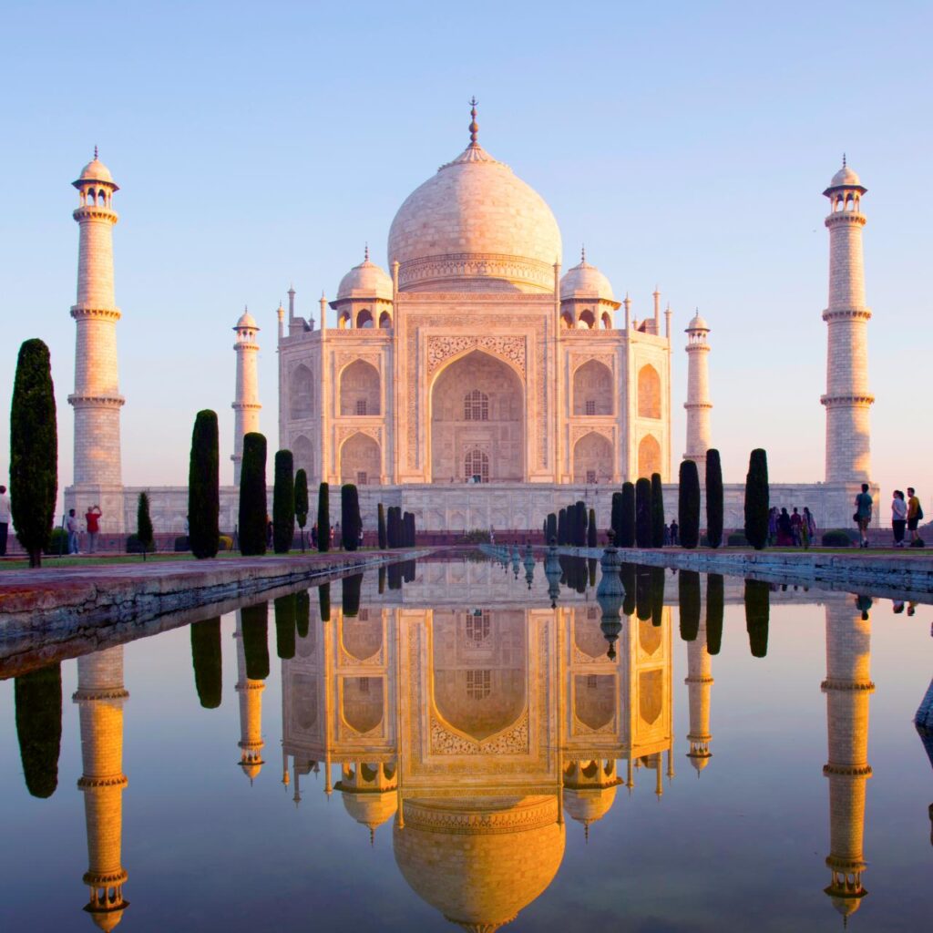 The Taj Mahal reflected in its watercourse at sunrise in India